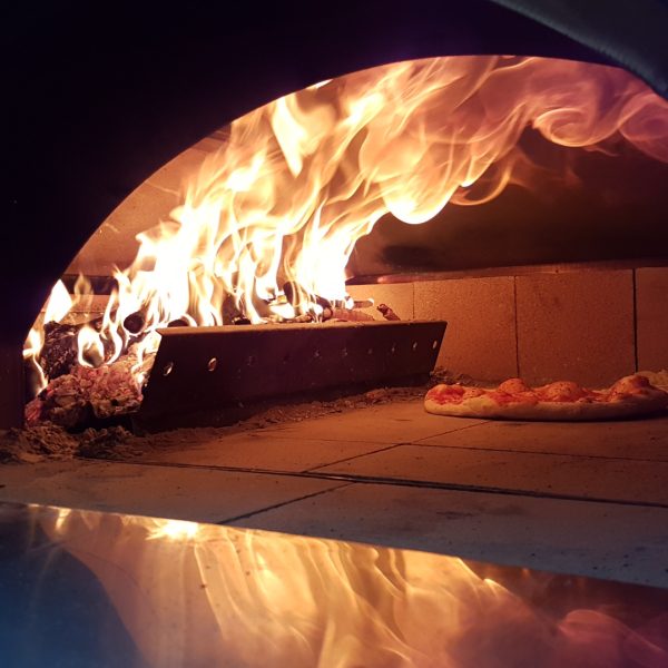 Pizza in brandende Clementi oven